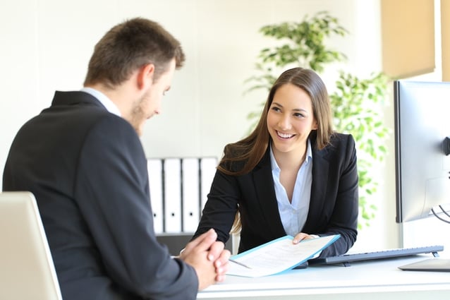 Young business woman smiling while working with a client.