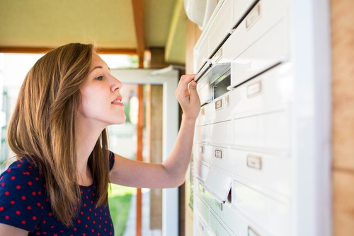 Professional woman looking into a secure mailbox
